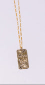 Gold necklace with a pendant on a light gray background