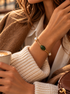 Girl in cafe wearing a cream sweater, tan jacket, brown hair and the olivine jade and pearl bracelet