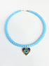 Necklace with light blue beads and a heart-shaped pendant on a white background