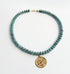 Necklace with blue beads and a gold pendant on a white background