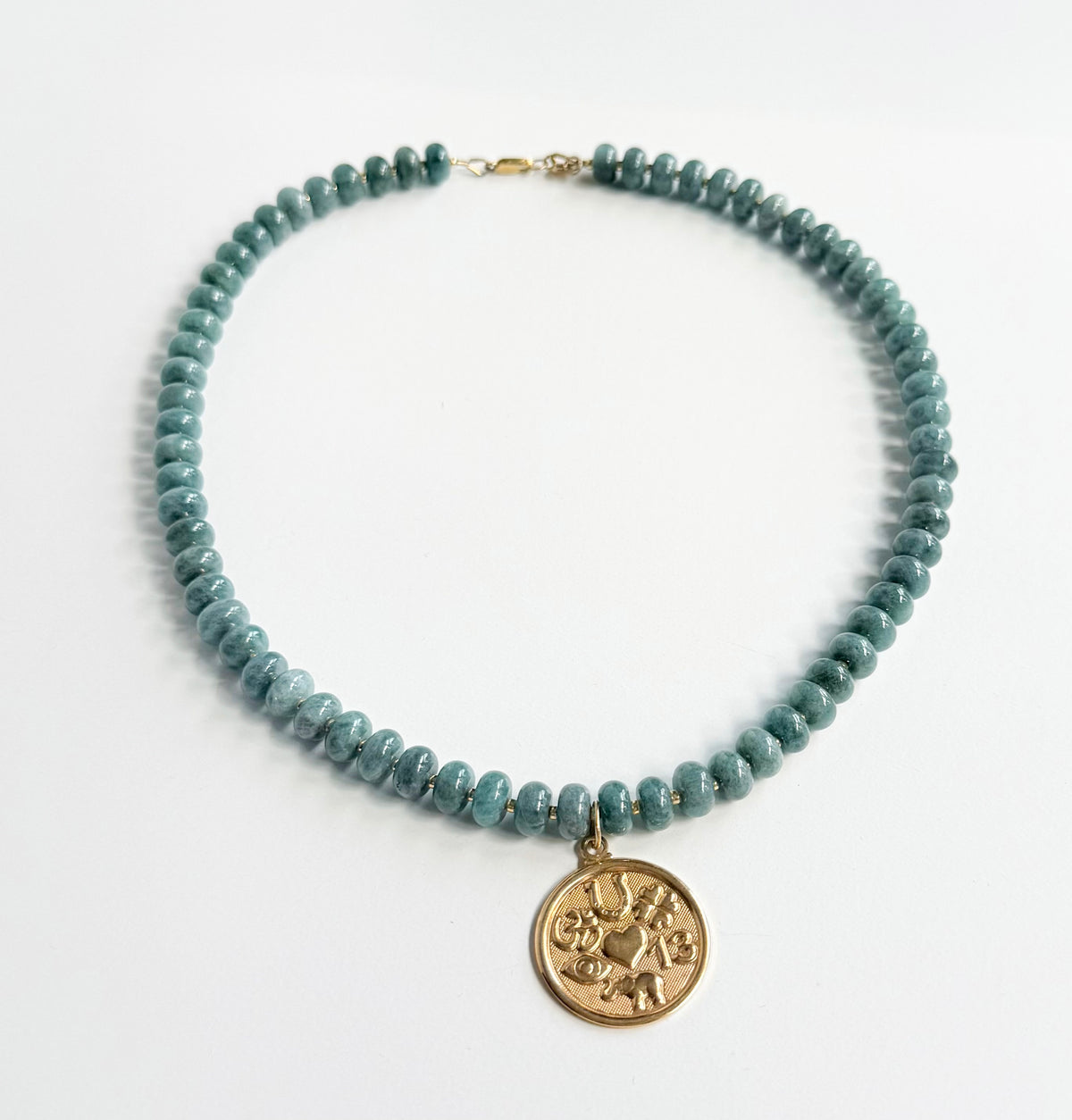 Necklace with blue beads and a gold pendant on a white background