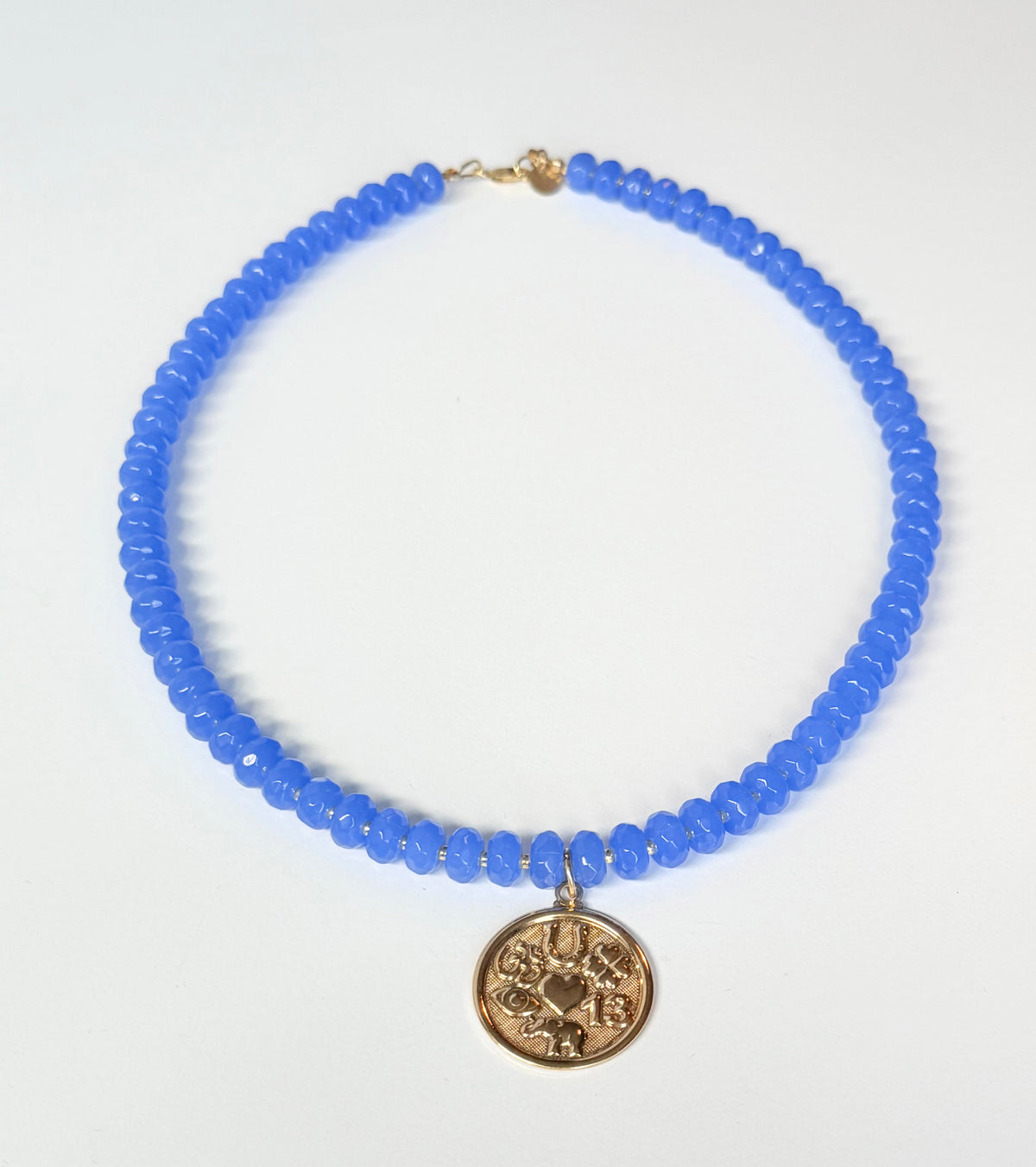 Blue beaded necklace with a gold pendant on a white background