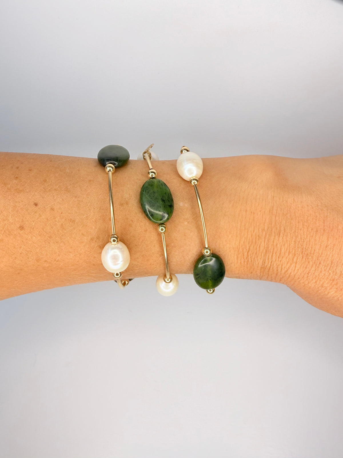 Olivine jade and freshwater pearl 14k gold-filled roll-on bracelets worn in a stack