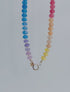 Movement and color detail shown of Multicolored beaded necklace on a white background