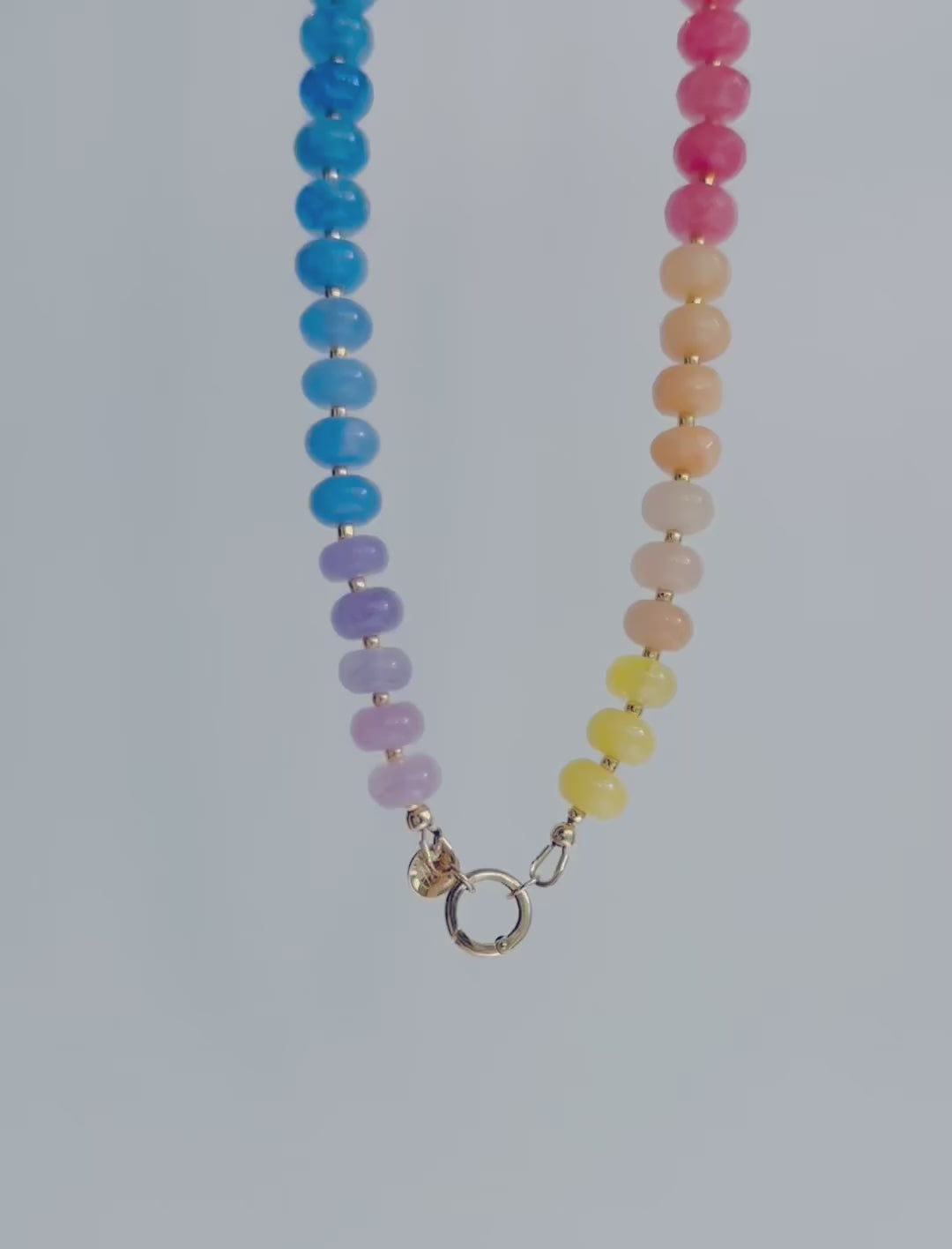 Movement and color detail shown of Multicolored beaded necklace on a white background